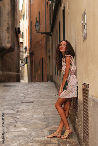 Happy cute girl, Palma, Mallorca (Majorca) Cinema effect. Vintage. Beautiful kind smile. Cinematic Film-Like. Attractive brunette with curly hair woman. Cute charming girl, Spain, Mallorca. 