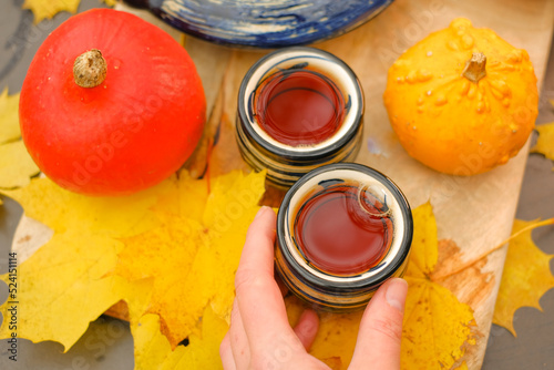 AutumnTea drinking.teapot and two striped cups in the garden on a sunny autumn day.mugs with hot drink and pumpkins with maple leaves.Cozy tea party in the autumn garden. Autumn cozy mood photo