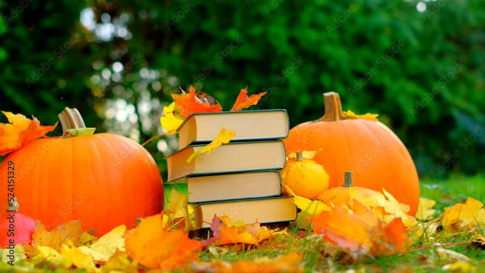 Books on the autumn theme.Back to school. Halloween Books. yellow leaves fall on books.Study and education concept. stack of books and maple orange leaves and pumpkins set in autumn garden 