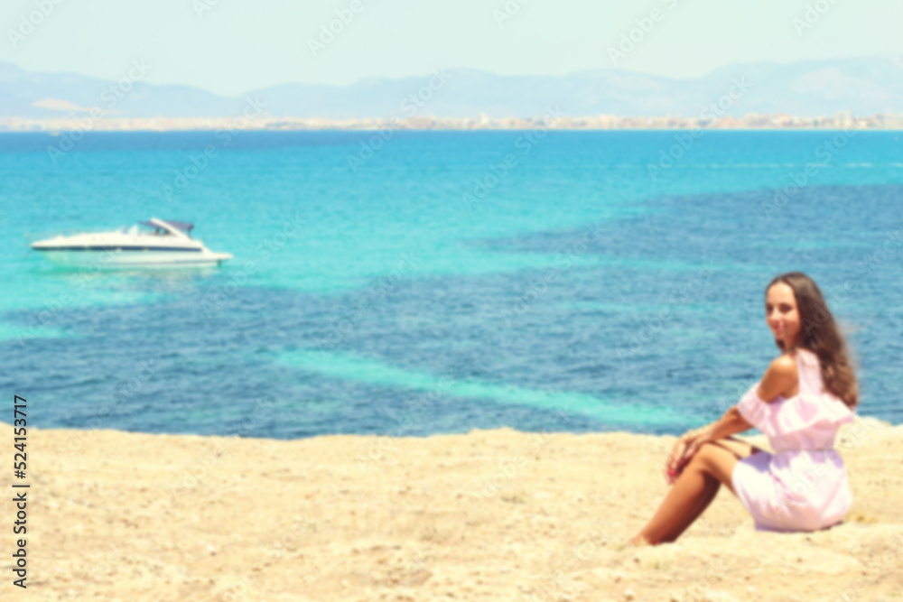 Defocus effect. Blurred silhouette Thoughtful girl by the sea. Blurred background. Relaxed atmosphere. Cute charming girl, Spain, Mallorca. 