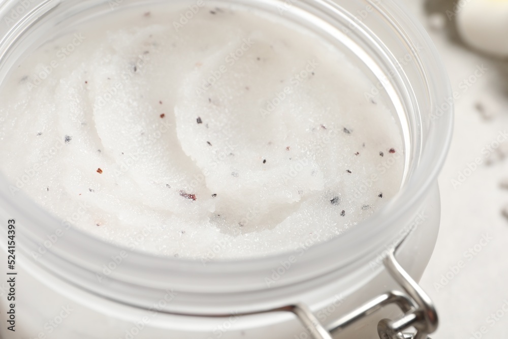 Body scrub in glass jar on table, closeup