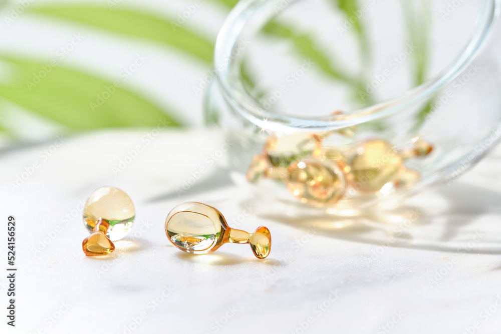 Serum capsules for healthy skin. Anti-wrinkle rejuvenation skin treatment. Beauty product presentation. Off white background with green palm leaf. Serum capsules for healthy skin. Anti-wrinkle rejuvenation skin treatment. Beauty product presentation. Off white background with green palm leaf.