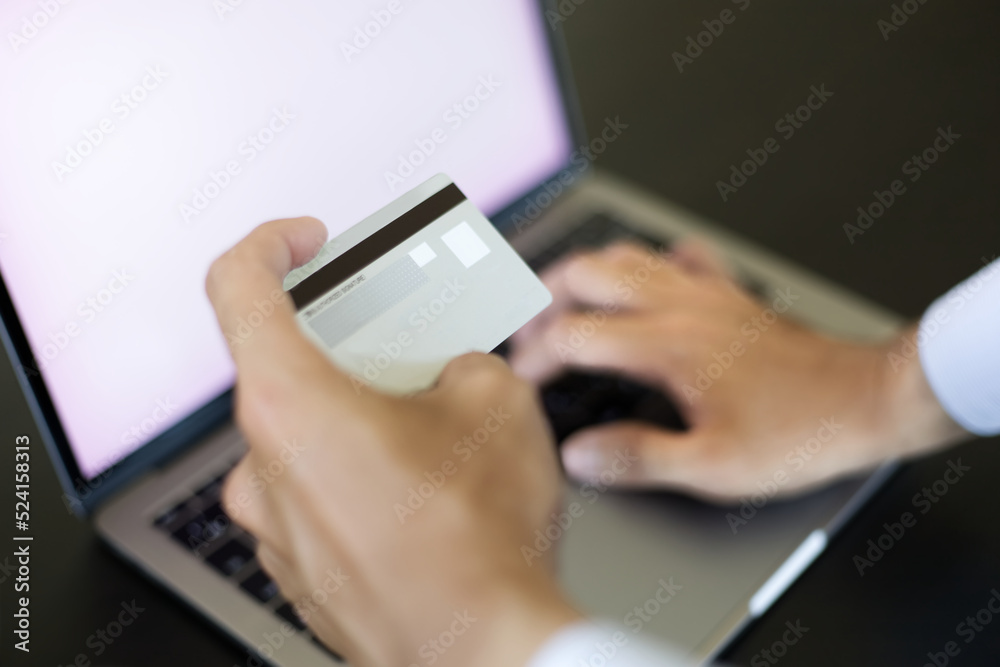 パソコンとクレジットカードで決済する男性　A man paying by a credit card and PC