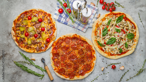 Pepperoni pizza , vegetarian pizza with vegetables and meat pizza with cucumbers on grey table top view