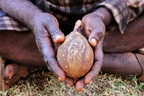Obraz na płótnie Indigenous Australian aboriginal man hands holding an engraved boab tree nut shell w salonie