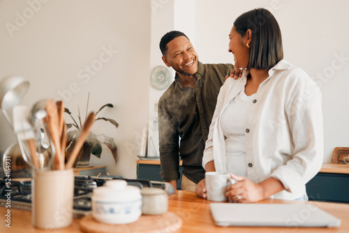 Smiling, laughing and loving, a couple in the kitchen with coffee. Happy, loving and relaxing, romantic new homeowners their house. Romance, marriage and fun, man and woman in love at the family home photo
