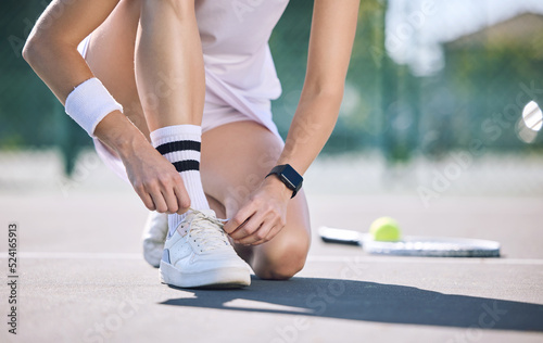 Female tennis player foot and hands tying shoelaces before game match on outdoor sports court. Active, sporty woman preparing for training for fun, summer exercise and healthy, wellness lifestyle.