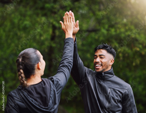 Active, fit and sporty athletes doing a high five to celebrate and congratulate on fitness goals. Healthy, happy and exercising couple motivated after training, getting cardio workout outside