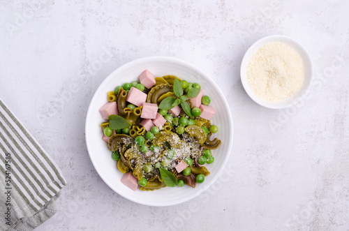 Green pasta with peas, sausages and cheese