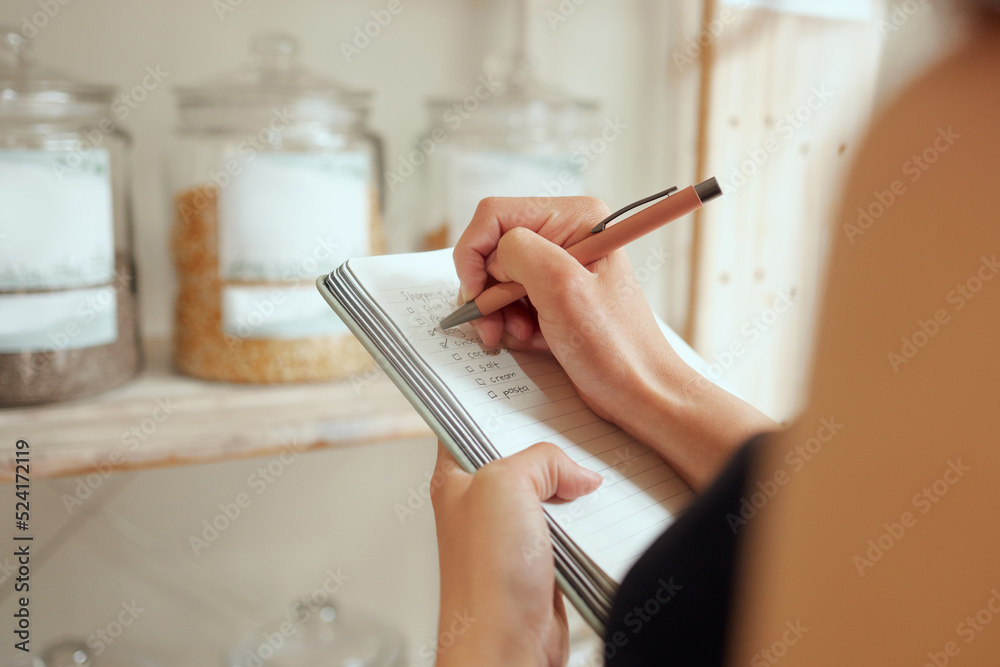 Entrepreneur stock counting and writing or planning shopping list in a store on a notepad. Small business owner making a budget for inventory and restocking of supplies in local store, shop or cafe - obrazy, fototapety, plakaty 