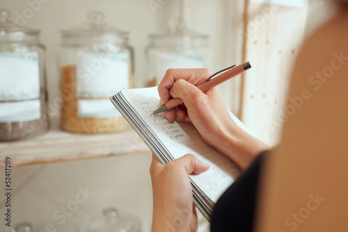 Entrepreneur stock counting and writing or planning shopping list in a store on a notepad. Small business owner making a budget for inventory and restocking of supplies in local store, shop or cafe © Kay A/peopleimages.com