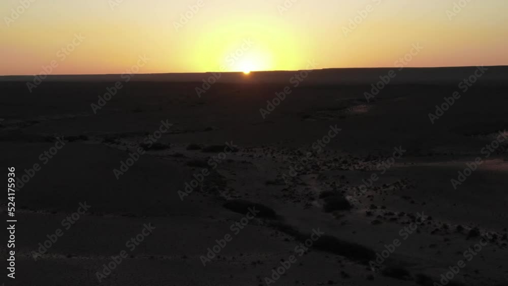 Backlit panoramic aerial drone sideways view of Martian Erfoud desert landscape in Morocco at sunset or sunrise Backlit panoramic aerial drone sideways view of Martian Erfoud desert landscape in Morocco at sunset or sunrise