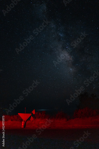 Milky way galaxy is faintly visible with stars over the Pacific Ocean as seen from Highway 1 in Big Sur, CA