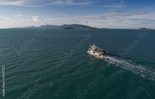 Ferry boat transport from Ko Samui island to Ko Pha Ngan island in southern Thailand - drone shot in mid ocean in evening light