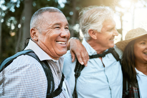 . Hiking, adventure and exploring with a carefree and excited male hiker with his senior friends outdoors. Enjoying a hike or walk in the forest or woods as a group of retired people for leisure.