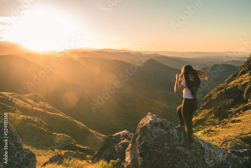 landscape with hikeer girl looking to the green mountains in a sunny morning