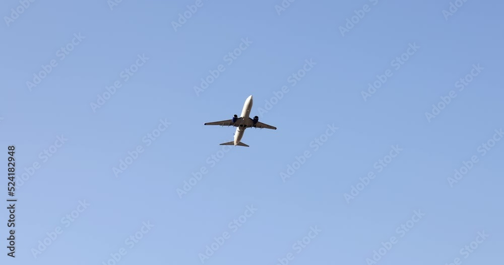 Plane is on approach and flies overhead on blue sky Plane is on approach and flies overhead on blue sky