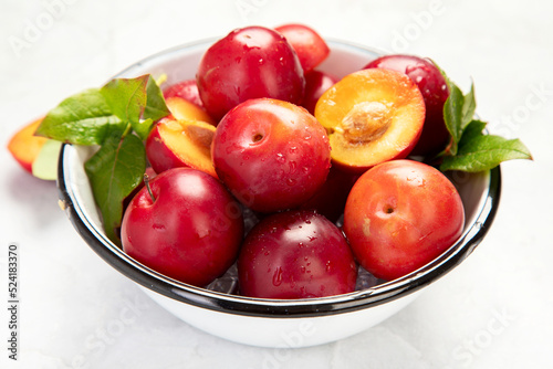 Plate of fresh ripe plums on table.