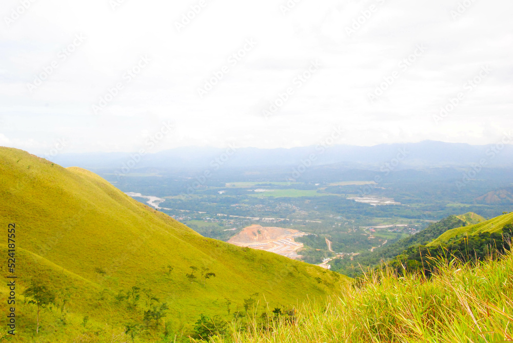 Naklejka premium Green hill landscape scenery with breathtaking views over the horizon on a summer day