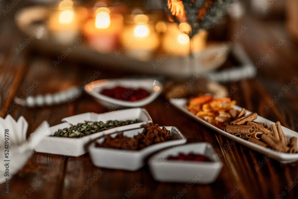 set of burning candles, small artificial Christmas trees and plates with spices on a wooden brown table, Christmas and New Year's concept, selective focus set of burning candles, small artificial Christmas trees and plates with spices on a wooden brown table, Christmas and New Year's concept, selective focus