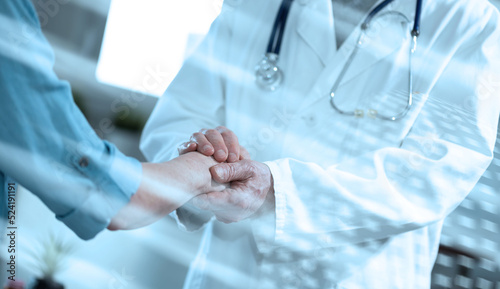 Doctor holding patient hand; light effect