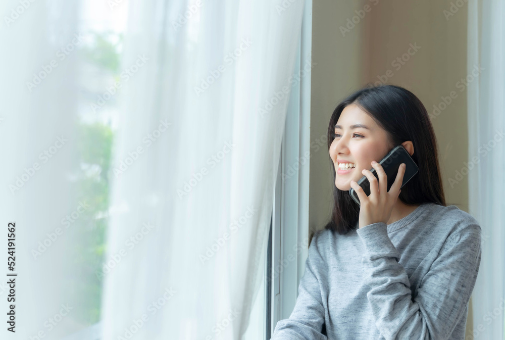 Lifestyle beautiful beauty woman Asian cute girl feel happy talking on smartphone to best friend in bedroom at home Lifestyle beautiful beauty woman Asian cute girl feel happy talking on smartphone to best friend in bedroom at home