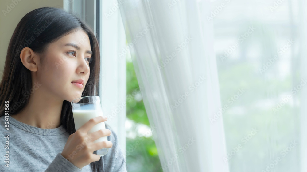 Beautiful beauty Asian woman cute girl drinking milk for good health in the morning , enjoying time in her home white bedroom background - lifestyle beauty woman concept Beautiful beauty Asian woman cute girl drinking milk for good health in the morning , enjoying time in her home white bedroom background - lifestyle beauty woman concept