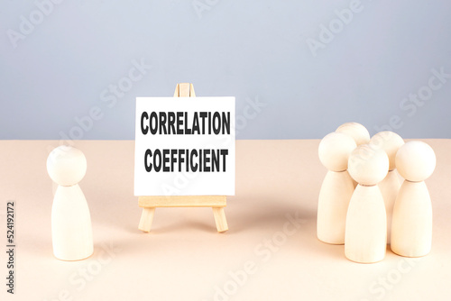 Fotografi Correlation Coefficient text on a easel with wooden figure, meeting concept