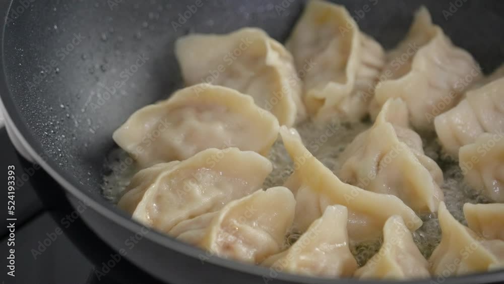 Pan-frying gyoza dumpling jiaozi at home. Pan-frying gyoza dumpling jiaozi at home.