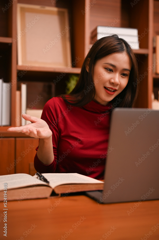 Attractive Asian businesswoman using laptop, having an online meeting conference with her team. Attractive Asian businesswoman using laptop, having an online meeting conference with her team.