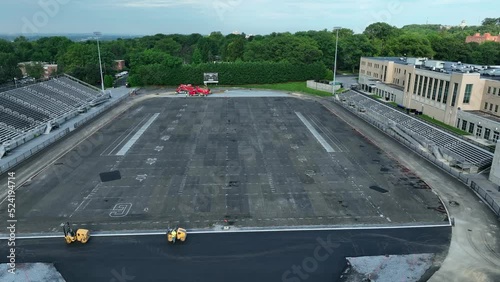 Old football field on school campus. Under construction and torn apart. Aerial zoom out of renovation. photo