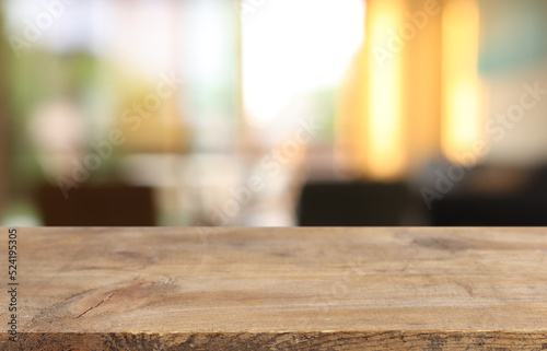 Wooden table and blurred window background, evening sunset light. Product display or mock up photo