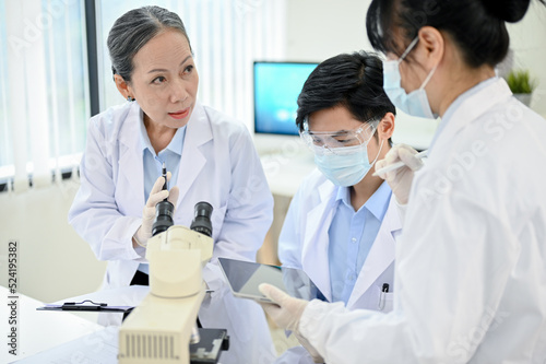 Fotografija A professional Asian senior female medical specialist training two young junior