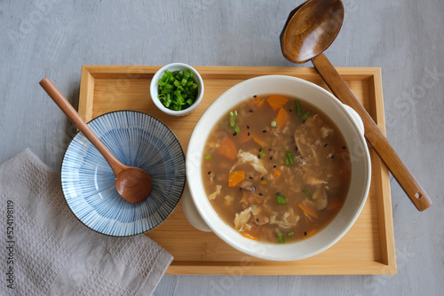 Delicious homemade Japanese meal. Zosui aka Ojiya. Rice in dashi soup stock with shiitake mushrooms, tofu, chicken breast meat, egg, carrot and spring onions photo