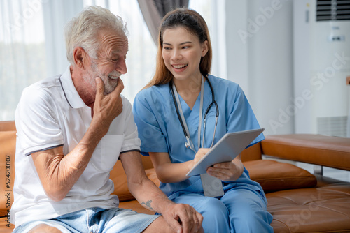 Assistance doctor uses tablet explain results of examination to senior old elderly man after treatment and checkup. Caregivers smile to encourage and care for patient. Health insurance  nursing homes