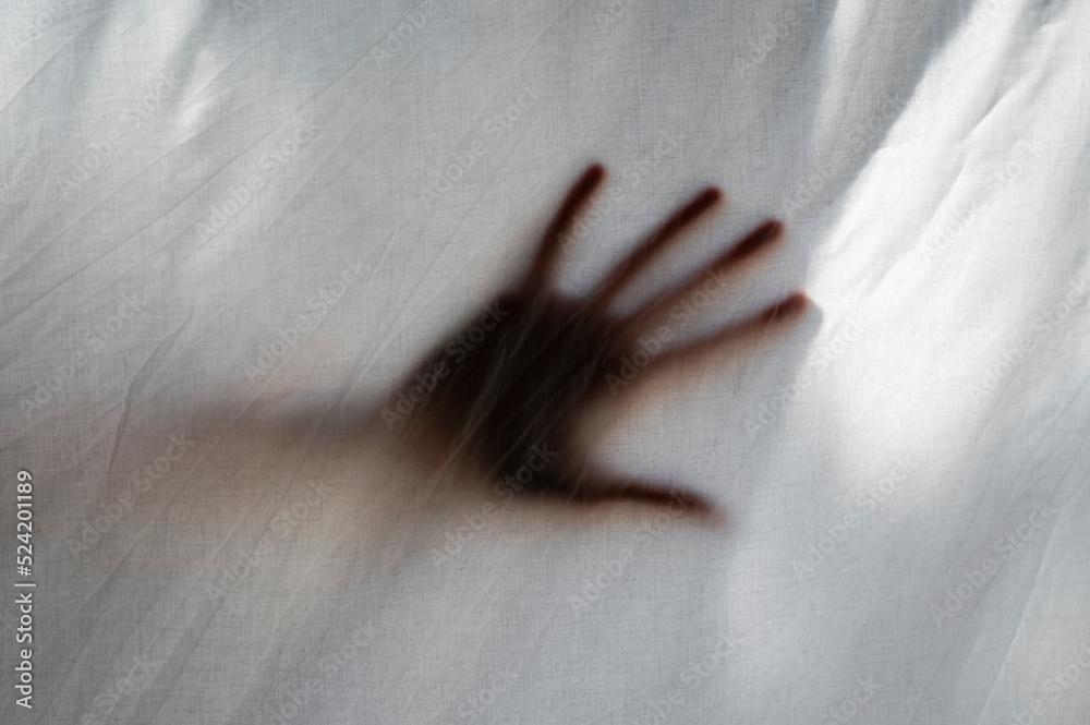 Hand shade behind a white sheet of anonymous person. Concept about mental health and illness, isolation, anxiety, stress, imprisonment. Hand shade behind a white sheet of anonymous person. Concept about mental health and illness, isolation, anxiety, stress, imprisonment.