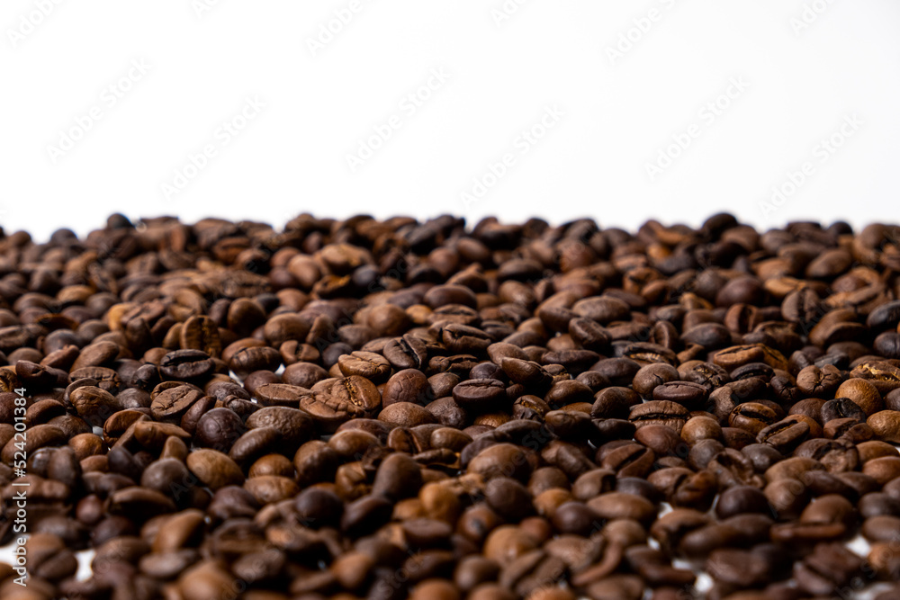 A scattering of coffee beans on a white background with space for text.