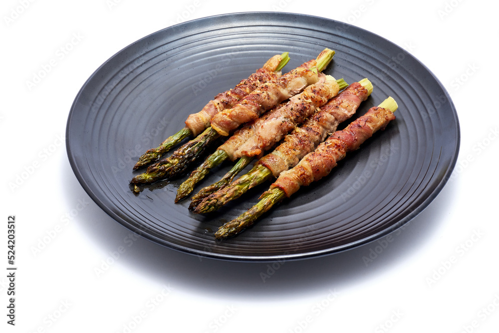 baked aspargus covered with bacon on ceramic plate isolated on white background baked aspargus covered with bacon on ceramic plate isolated on white background