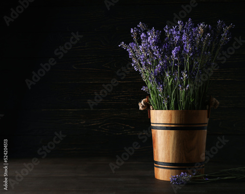 Wooden bucket with lavender on wooden background