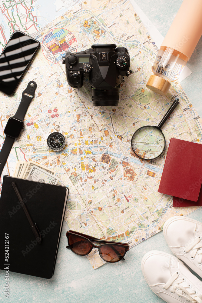 Flat lay traveler accessories on map, camera, glasses, digital devices