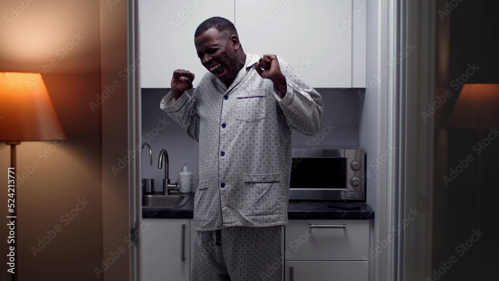 Sleepy African-American man yawn and stretch standing in kitchen early in morning Sleepy African-American man yawn and stretch standing in kitchen early in morning