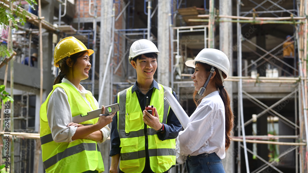 Shot of two female architect discussing with male engineer manager about construction project 