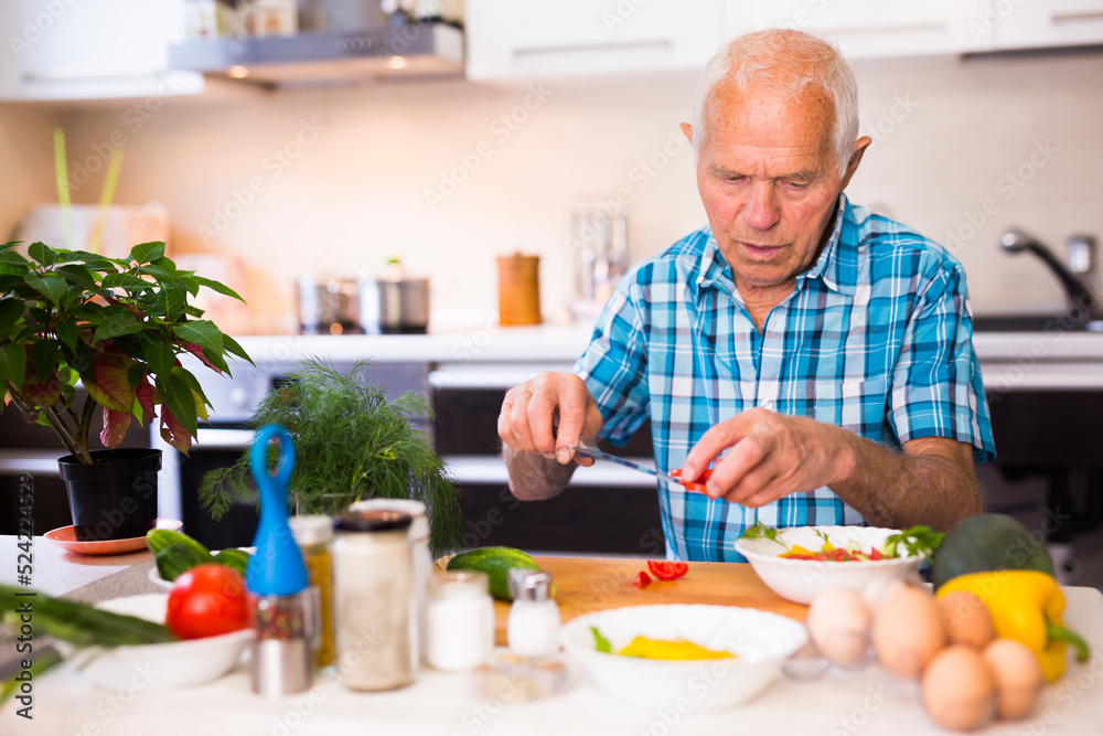 senor man preparing fresh vegetable salad at home in the kitchen senor man preparing fresh vegetable salad at home in the kitchen