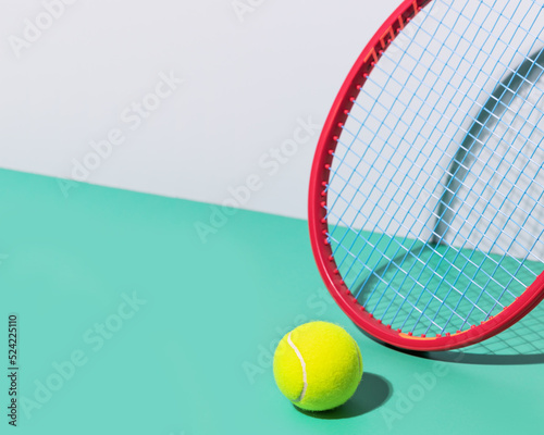 Minimalistic, tennis composition with red tennis racket and yellow, tennis ball on a blue background with copy space. Tennis competition. Selective focus, closeup © KRISTINA KUPTSEVICH
