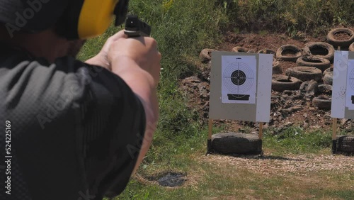 Footage of a man shooting towards a target with his gun