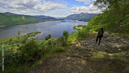 Woman female taking a photograph on a mobile phone View across Derwentwater in the English Lake District looking towards the town of Keswick with Skiddaw photo