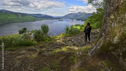 Woman female taking a photograph on a mobile phone View across Derwentwater in the English Lake District looking towards the town of Keswick with Skiddaw photo
