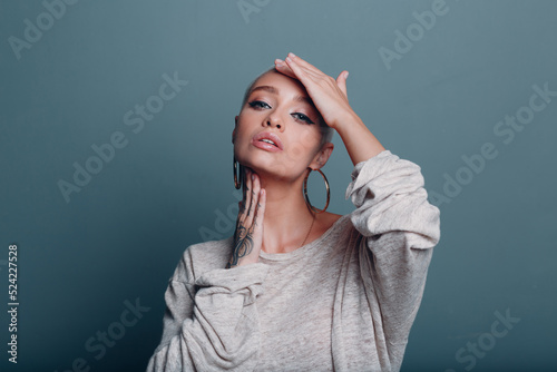 Millenial young woman with short blonde hair portrait doing face yoga self facebuilding massage for facial skin photo