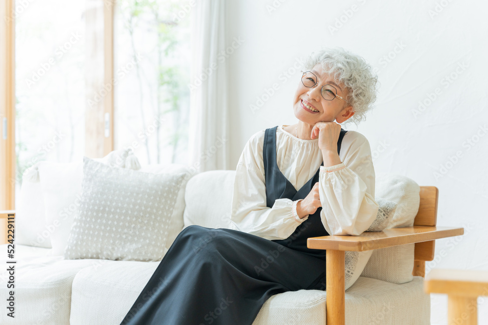 ソファーに座ってくつろぐシニア女性
