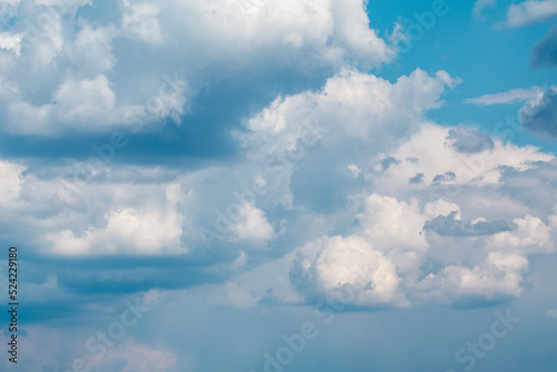 White layered clouds on bright blue sky, cloudscape background. Skyscape natural heavenly scenery